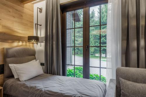 a bedroom with a bed and a large window at Bukovel Hotel in Bukovel
