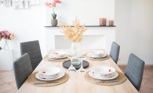 a dining room table with chairs and a vase of flowers at Charming room apartment in Dunkerque