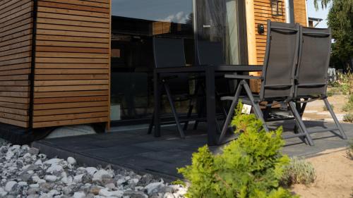 a black table and two chairs on a patio at Tiny House 2 Dünenblick in Freest
