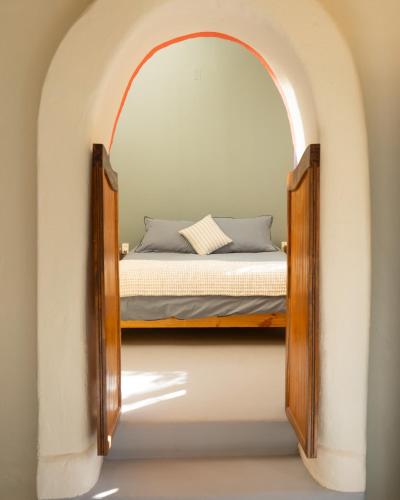 a bedroom with a bed in an archway at El jardín secreto Pisco Elqui in Pisco Elqui