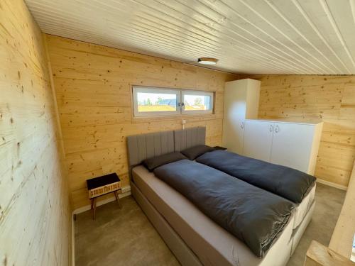 a bedroom with a large bed in a wooden wall at Tiny House 5 Seestern in Freest