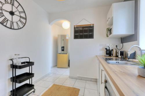 a kitchen with a sink and a clock on the wall at Apt Le Sunny - T4 Boucan Canot in Saint-Paul