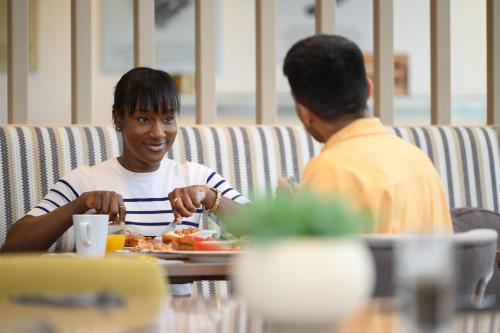 a man sitting at a table with a plate of food at Edgbaston Park Hotel Birmingham in Birmingham