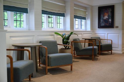 a waiting room with chairs and tables and windows at Edgbaston Park Hotel Birmingham in Birmingham