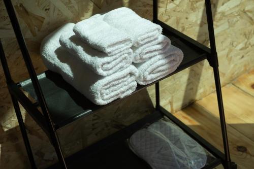 einen Stapel Handtücher auf einem Kleiderständer im Bad in der Unterkunft OKON Highlands Cottages & Camp in Yenokavan