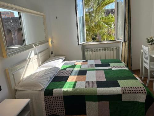 ein Schlafzimmer mit einem Bett mit einer bunten Decke darauf in der Unterkunft Villa Lanusei in Rom