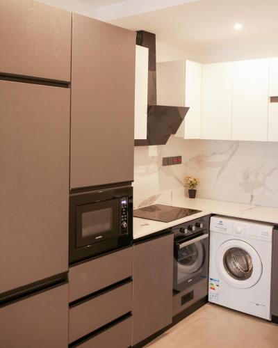 a kitchen with a washing machine and a washer at Akwaaba Retreats in Tema