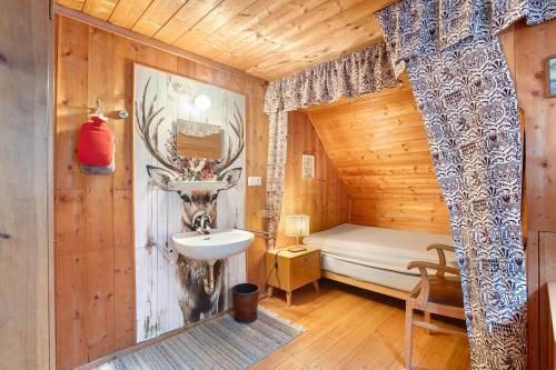 a bathroom with a sink and a bed in a cabin at Zähringer Hütte in Menzenschwand-Hinterdorf