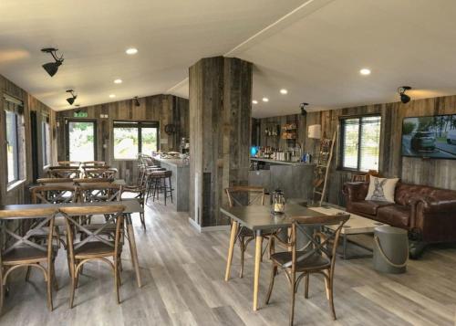 a restaurant with tables and chairs and a couch at Clumber Park Lodges in Worksop
