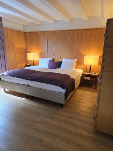 a bedroom with a large bed with two lamps at Olympia Hotel Zurich in Zürich