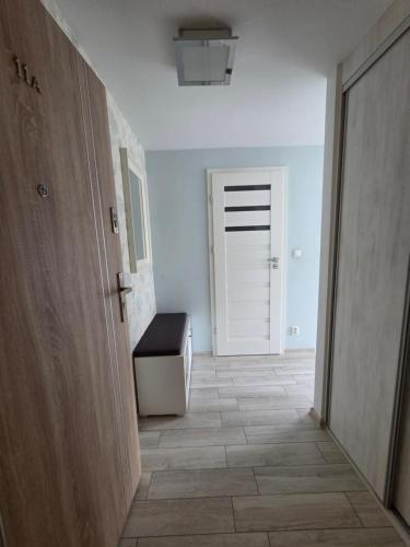 a hallway with a door and a bench in a room at Apartament COMFORT Centrum 2 in Krotoszyn