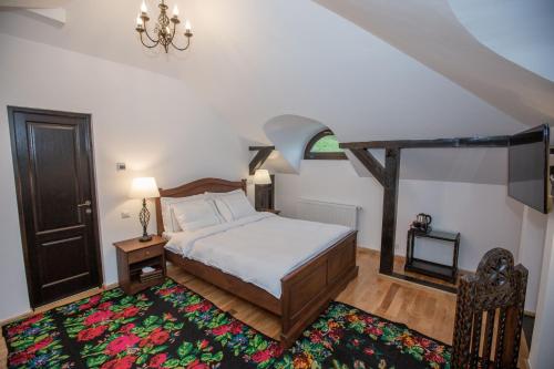 a bedroom with a bed and a chandelier at Odaile Brancovenesti -Maldaresti in Măldăreşti