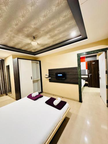 a bedroom with a white bed and a mirror at Hotel Diamond Executive in Solapur