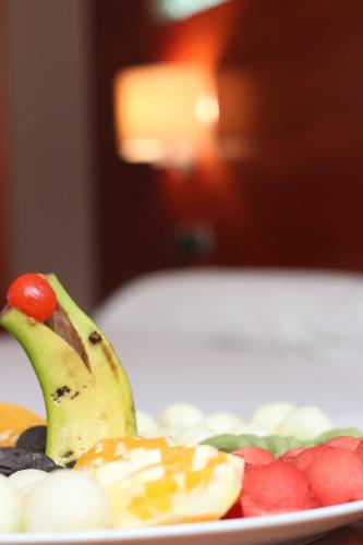 a plate of fruit with a banana and strawberries at Hotel Balneario Valle del Jerte in Valdastillas
