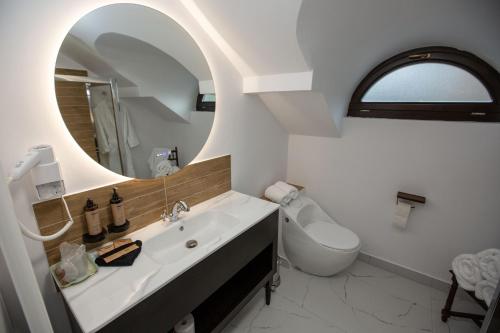 a white bathroom with a sink and a mirror at Odaile Brancovenesti -Maldaresti in Măldăreşti