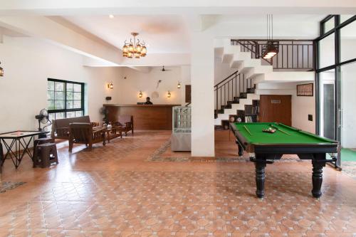 a living room with a pool table and stairs at Vaarsa by Bay Hotels in Alibaug