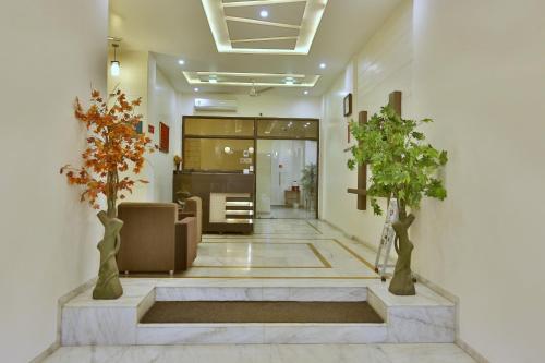 a lobby with two trees in a building at Hotel Kamran Palace in Ahmedabad