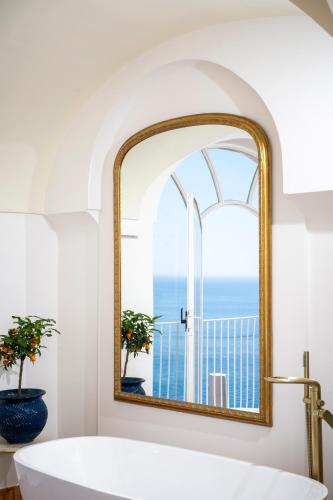 a bathroom with a large mirror and a tub at Villa Santa Chiara Positano Suites in Positano
