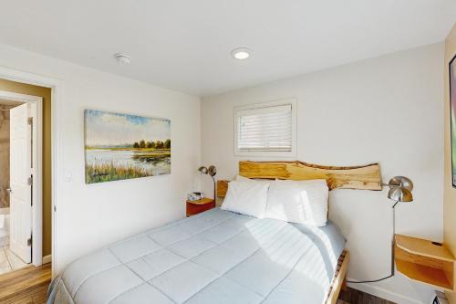 ein Schlafzimmer mit einem Bett und einem Gemälde an der Wand in der Unterkunft Moose Meadow Cottage in Anchorage