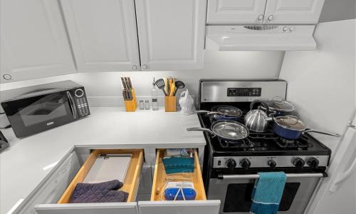 a kitchen with white cabinets and a stove at The Jefferson Emerald City View in Belle Haven