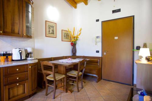 a kitchen with a table and chairs and a table and a door at Fiordaliso in Montichiari