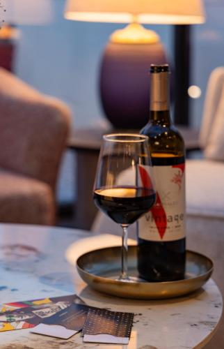 a bottle of wine and a glass on a table at Iconic Hotel in Tel Aviv