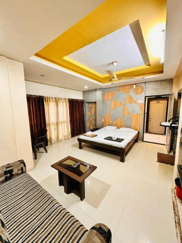 a bedroom with a bed and a table in a room at Hotel Diamond Executive in Solapur