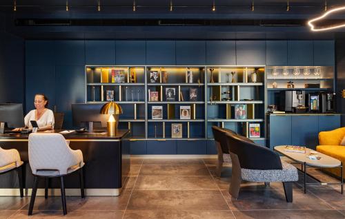a woman sitting at a desk in front of a computer at Iconic Hotel in Tel Aviv