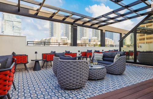 a rooftop patio with chairs and tables on a building at Iconic Hotel in Tel Aviv