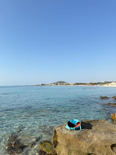 a hat and a towel sitting on a rock in the water at Villa Ryma in Kelibia Center in Kelibia