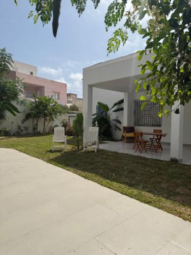 a group of chairs sitting in the yard of a house at Villa Ryma in Kelibia Center in Kelibia