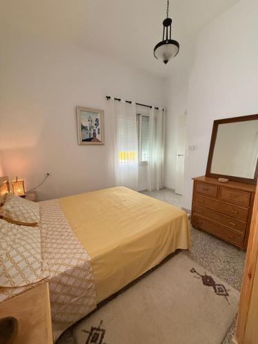 a bedroom with a bed and a dresser and a television at Villa Ryma in Kelibia Center in Kelibia