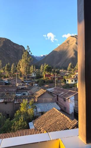 a view of a city with mountains and roofs at Hotel Quilla House 2 in Urubamba