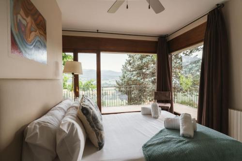 a bedroom with a large bed and a large window at Masia Boutique con Infinity Pool in Calvinyá