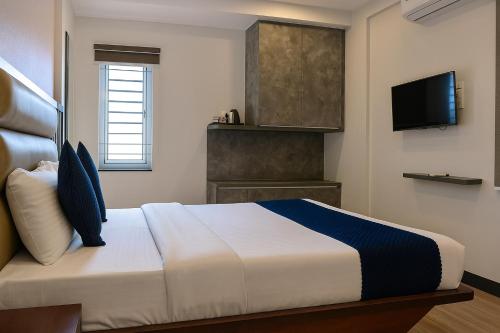 a bedroom with a bed and a television in it at Hotel Rize Inn in Bengaluru