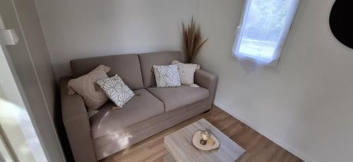 a couch in a living room with pillows on it at Love room avec jaccuzi privé in Perpignan