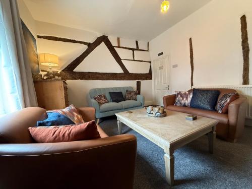 a living room with two couches and a coffee table at The Whitchurch Apartment- The Painted Rooms in Whitchurch