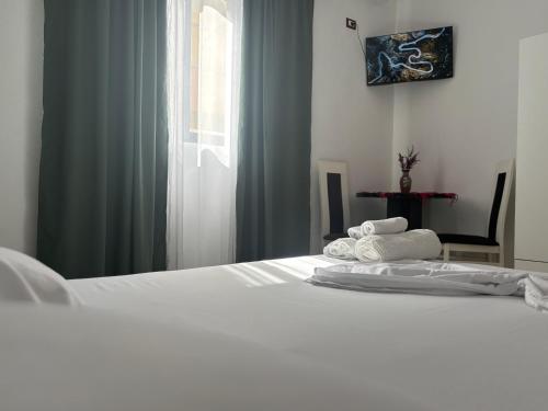 a white bed in a room with a window at Villa Zeqaj in Durrës