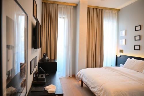 a bedroom with a bed and a large window at Bazaar Inn Hotel in Tirana