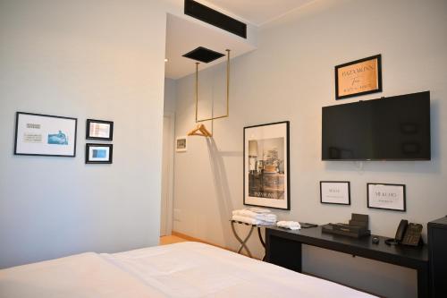 a bedroom with a bed and a desk with a television at Bazaar Inn Hotel in Tirana