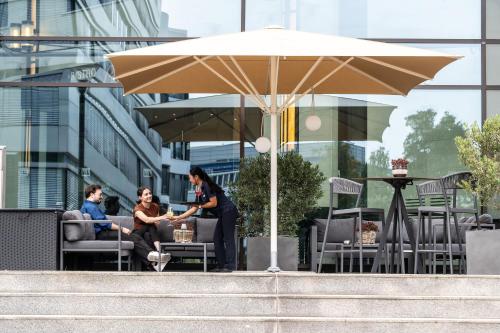 a group of people sitting in chairs under an umbrella at Maritim Hotel Düsseldorf in Düsseldorf