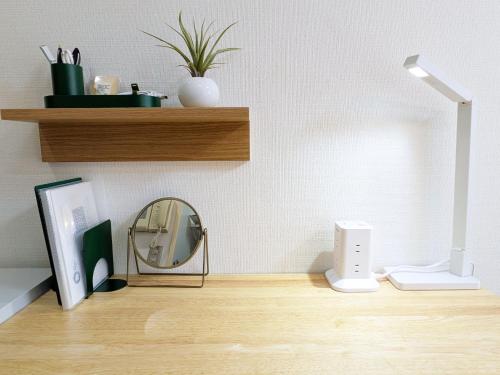 a mirror and a lamp on a wooden table at Laze Nakano 2bed Travel Work Broadway in Tokyo