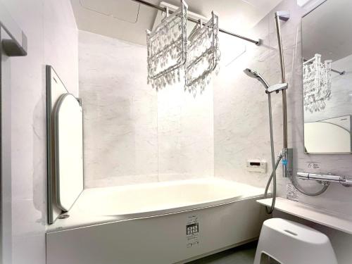 een witte badkamer met een bad en een toilet bij Modern Tokyo Suites in Tokyo