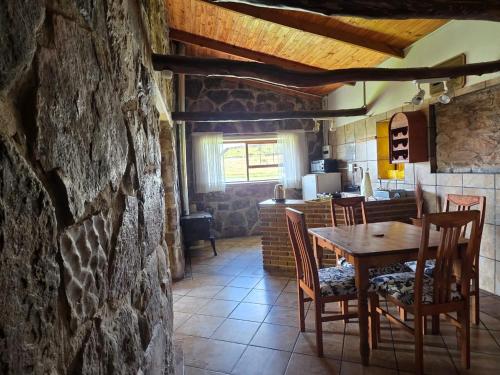 a dining room with a wooden table and chairs at Treeferns Trout Lodge in Dullstroom