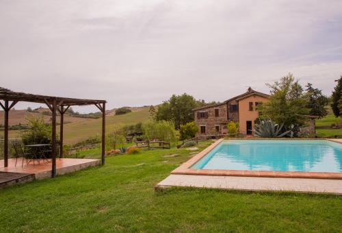 a swimming pool in a yard with a house at Casale meraviglioso Val d'Orcia con piscina in Radicofani