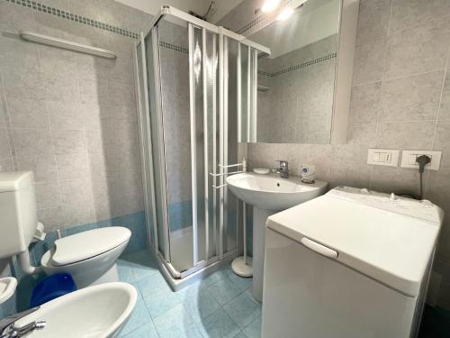 a bathroom with a shower and a toilet and a sink at Cozy flat with shared pool in Porto Santa Margherita di Caorle