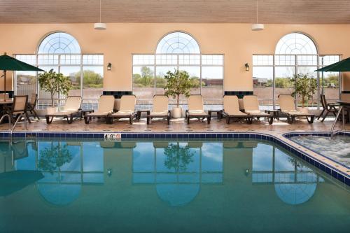 a pool at a hotel with chairs and tables at Country Inn & Suites by Radisson, Milwaukee West Brookfield , WI in Brookfield