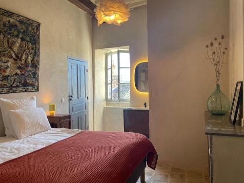 a bedroom with a bed with a red blanket and a window at Ancienne eglise in Vallérargues