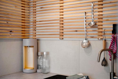 a kitchen with wooden blinds and a counter with bottles at Ruhbauernhof in Kirchzarten