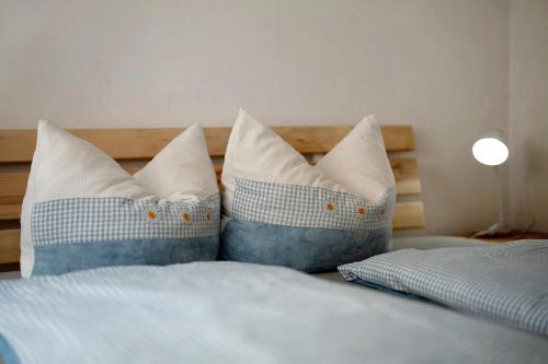 a bed with blue and white pillows on it at Ruhbauernhof in Kirchzarten